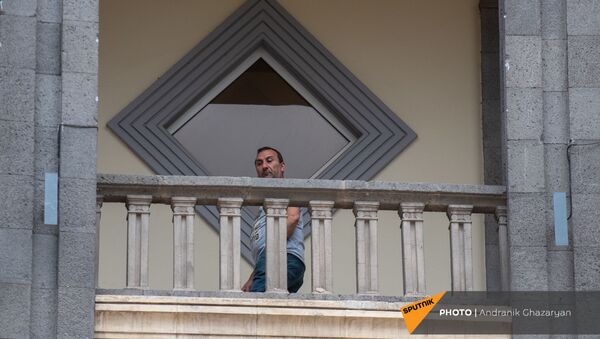 Мужчина наблюдает за митингом движения 5165 с требованием опубликовать договор с Азербайджаном (22 мая 2021). Еревaн - Sputnik Армения