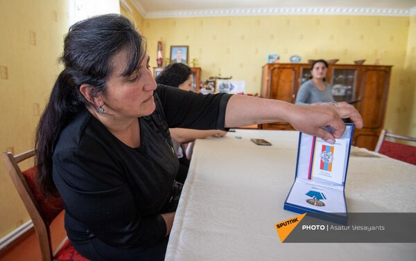 Мама погибшего добровольца Ованеса Маркосяна Анаит показывает медаль сына За храбрость - Sputnik Армения