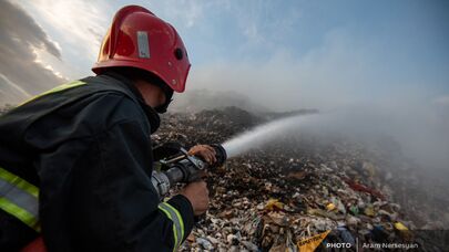 Сотрудник МЧС тушит пожар на нубарашенской мусорной свалке
