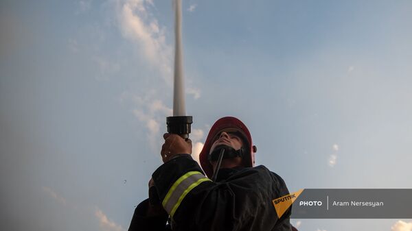 Сотрудник МЧС тушит пожар на нубарашенской мусорной свалке - Sputnik Արմենիա