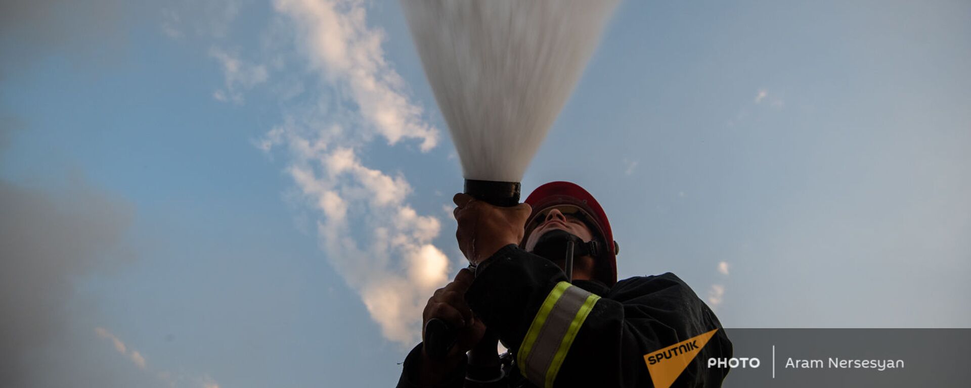Сотрудник МЧС тушит пожар на свалке в Нубарашене - Sputnik Արմենիա, 1920, 25.07.2021