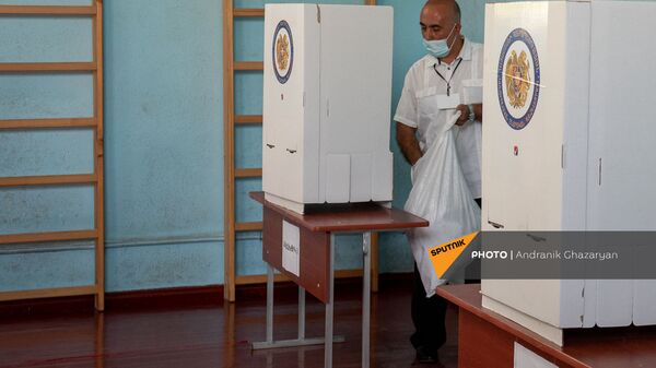Член избирательной комиссии участка 29/29 удаляет неиспользованные бюллетени из избирательных кабин (20 июня 2021). Село Ариндж - Sputnik Армения