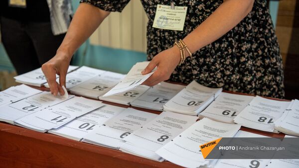 Сотрудник избирательной комиссии собирает пакет бюллетеней в избирательном участке 29/29 (20 июня 2021). Ариндж - Sputnik Արմենիա