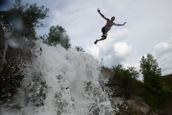 Молодой человек прыгает с водопада на реке Выдриха в Новосибирской области - Sputnik Армения