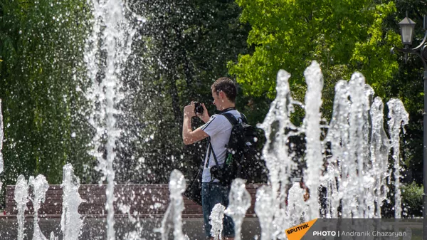 Молодой человек фотографирует фонтаны в парке 2800-летия Еревана - Sputnik Армения