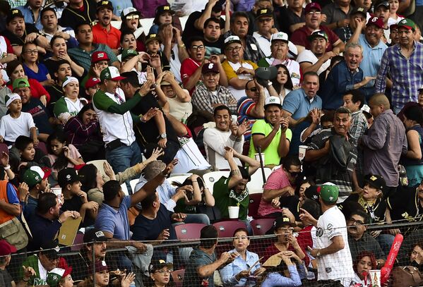 Люди в зале спасаются от бейсбольной биты во время матча Карибской бейсбольной серии на стадионе Томатерос в Кулиакане, штат Синалоа, Мексика,  2017 год - Sputnik Армения