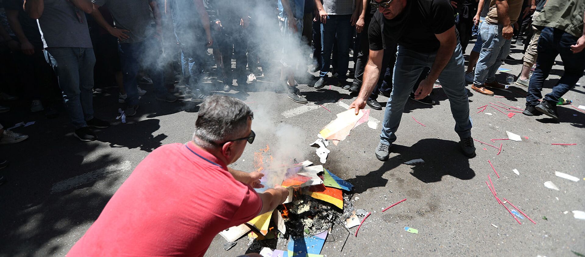 Протестующие против ЛГБТ сжигают радужный баннер во время митинга перед запланированным Маршем достоинства (5 июля 2021). Тбилиси - Sputnik Армения, 1920, 05.07.2021