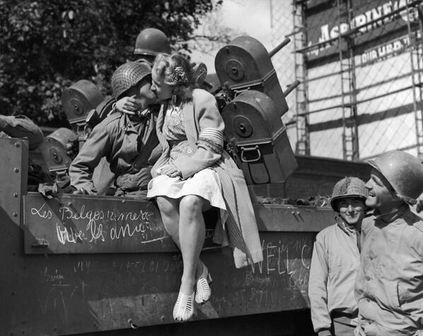 Солдат получает поцелуй от бельгийской женщины после того, как американские войска вошли в Льеж, город, освобожденный от немцев - Sputnik Армения