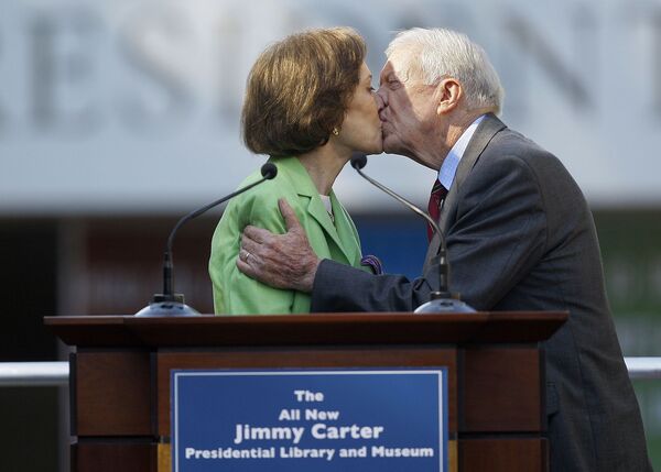 Бывший президент США Джимми Картер целует свою жену Розалин во время церемонии открытия недавно реконструированной Президентской библиотеки Картера (7 июля 2021). Атланта - Sputnik Армения