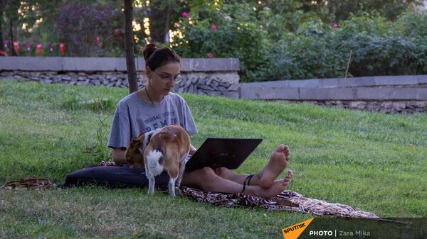 Девушка с ноутбуком и собакой на газоне в парке Тумо - Sputnik Армения