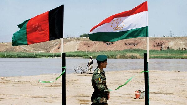Солдат Афганской национальной армии у флагов Афганистана и Таджикистана (18 июня 2005). Кундуз - Sputnik Армения