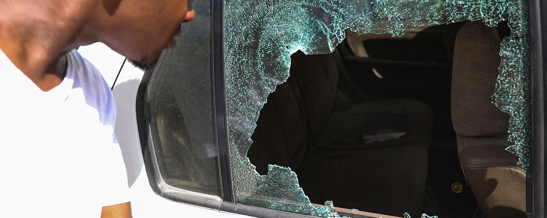 Мужчина смотрит на пулевые отверстия в машине возле президентской резиденции в Порт-о-Пренсе (7 июля 2021). Гаити - Sputnik Армения, 1920, 09.07.2021