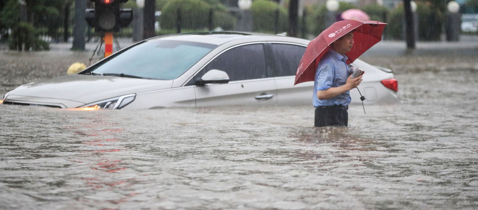 Мужчина у затопленной в результате проливных дождей машины после проливных дождей в Чжэнчжоу в центральной провинции Китая Хэнань - Sputnik Արմենիա, 1920, 21.07.2021