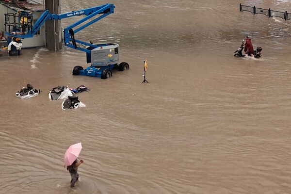 Люди идут по затопленным улицам после проливных дождей в Чжэнчжоу в центральной провинции Китая Хэнань - Sputnik Армения