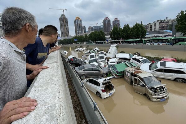 Люди смотрят на затопленные машины в Чжэнчжоу (20 июля 2021). Китай - Sputnik Армения