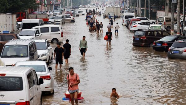 Люди переходят паводковые воды после проливных дождей в Чжэнчжоу, провинция Хэнань, Китай - Sputnik Армения