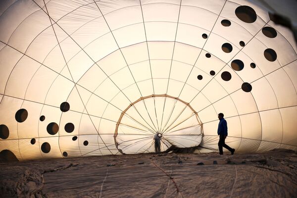 Члены экипажа осматривают частично надутый воздушный шар на Bristol International Balloon Fiesta в Бристоле, Великобритания - Sputnik Армения