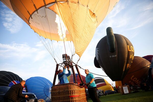 Члены экипажа надувают воздушный шар на Bristol International Balloon Fiesta в Бристоле - Sputnik Армения
