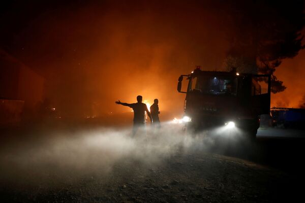 Пламя поднимается рядом с пожарными машинами во время лесного пожара в деревне Ровиес на острове Эвия - Sputnik Армения