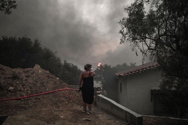 Местная жительница в маске в ​​лесу Татой недалеко от Ахарнеса, где вспыхнул лесной пожар - Sputnik Армения