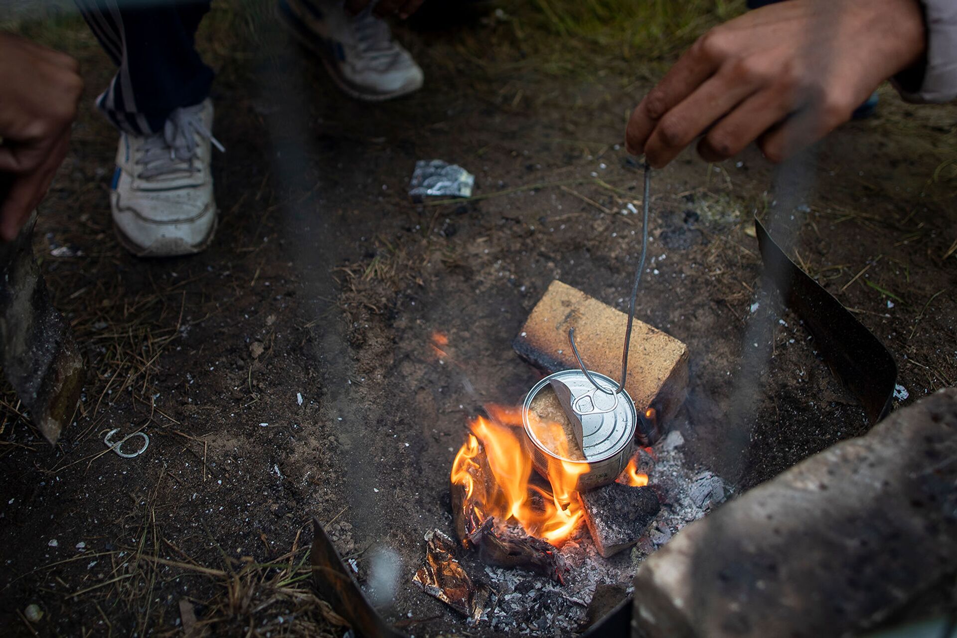 Мигранты готовят еду в недавно построенном лагере беженцев на военном полигоне Руднинкай (6 августа 2021). Литва - Sputnik Армения, 1920, 14.09.2021