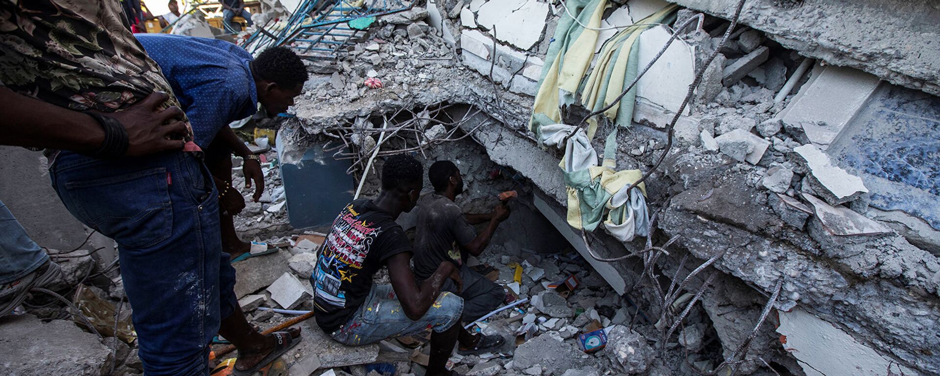 Люди ищут выживших в доме, разрушенном в результате землетрясения силой 7,2 балла в Ле-Ке (15 августа 2021). Гаити - Sputnik Армения, 1920, 18.08.2021