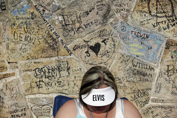 Поклонник Элвиса Пресли Адриан Корнелиус стоит в очереди у покрытой граффити стены перед Грейслендом, домом Пресли в Мемфисе. - Sputnik Армения