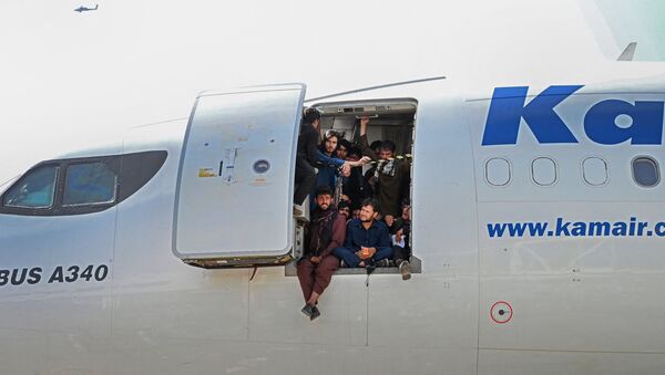Афганцы сидят в дверях самолета в аэропорту Кабула  - Sputnik Армения