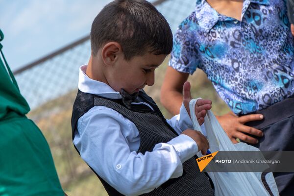 Первоклассник Ваге Овсепян рассматривает подарки у кармраванской основной школы - Sputnik Армения
