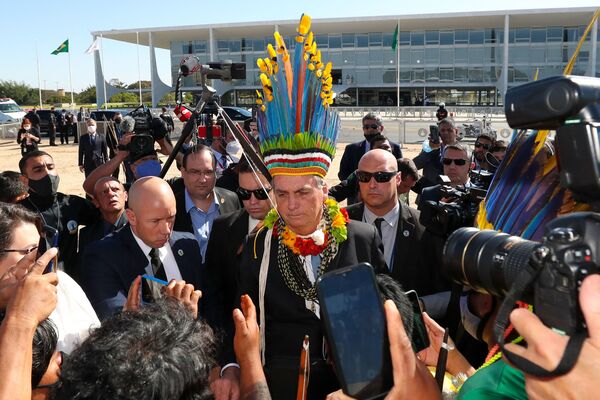 Президент Бразилии Жаир Болсонару в головном уборе коренного населения во время встречи с коренными народами на 3 Poderes Plaza (12 августа 2021).Бразилиа - Sputnik Армения