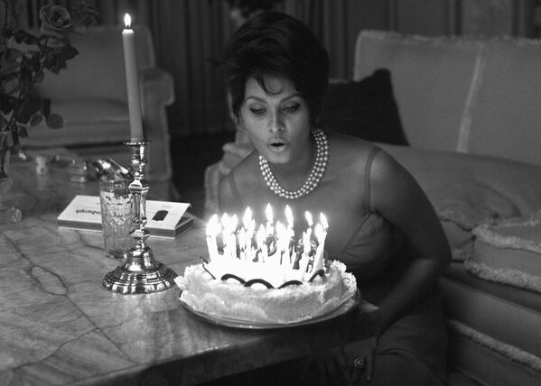 Итальянская актриса готовится задуть свечи на торте в день 27-летия в своем доме в Риме. - Sputnik Армения
