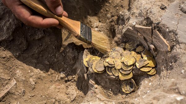 Археолог очищает обнаруженные на месте раскопок золотые монеты (18 августа 2020). Израиль - Sputnik Армения