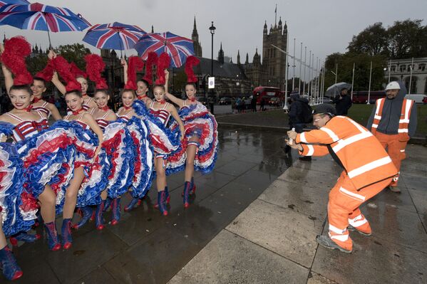 Танцовщицы фотографируются под зонтиками у здания парламента в Лондоне 4 ноября 2016 года во время рекламной фотосессии - Sputnik Армения