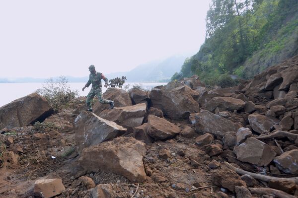 Военнослужащий Индонезии идет по оползневой зоне после землетрясения силой 4,8 балла, произошедшего на Бали. - Sputnik Армения