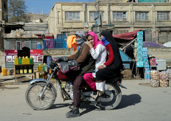 Афганская семья проезжает на мотоцикле мимо придорожных магазинов в Кабуле, Афганистан. - Sputnik Армения