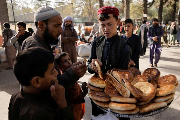 Мальчик продает хлеб во временном убежище для перемещенных афганских семей, спасающихся от насилия в своих провинциях, Кабул - Sputnik Армения