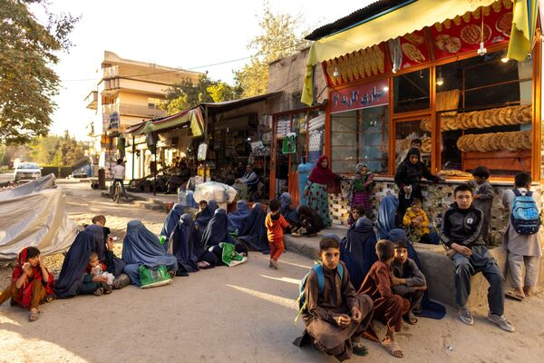 Женщины и дети выстроились в очередь возле пекарни в Кабуле, ожидая раздачи бесплатного хлеба. - Sputnik Армения