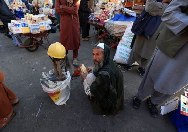 55-ամյա Գուլ Մոհամմադը Քաբուլի շուկայում նստել է իր գործիքների կողքին ու նախաճաշում է։ - Sputnik Արմենիա