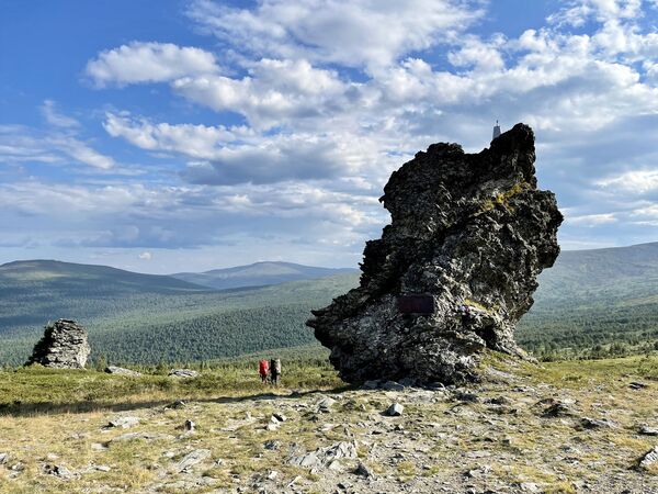 Туристы летом спускаются с перевала Дятлова.По поводу загадочной гибели туристической группы Дятлова в 1959 году было много гипотез: сход лавины, испытания секретного оружия, снежный человек, НЛО, убийство, шаровая молния… Туристы, приезжающие к горе Холатчахль, своими глазами хотят увидеть это место. - Sputnik Армения