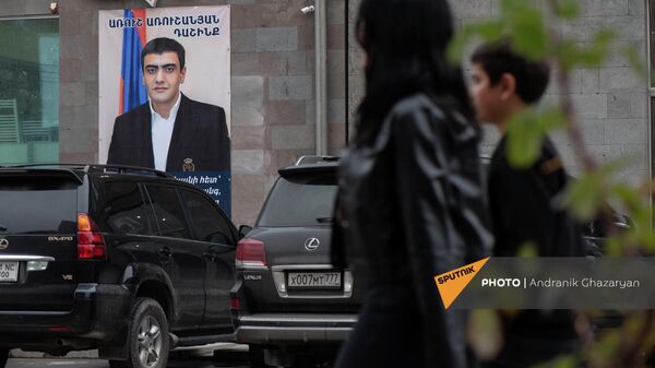 Люди проходят мимо агитационного предвыборного плаката блока Аруша Арушаняна в Горисе - Sputnik Արմենիա