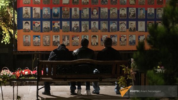 Брат и друзья погибшего военнослужащего у стены памяти в Степанакерте - Sputnik Армения