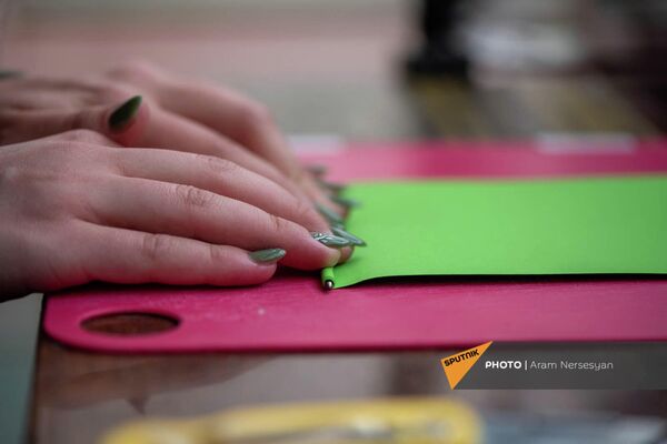 Сотрудница заворачивает ручку Eco pen из переработанной бумаги - Sputnik Армения