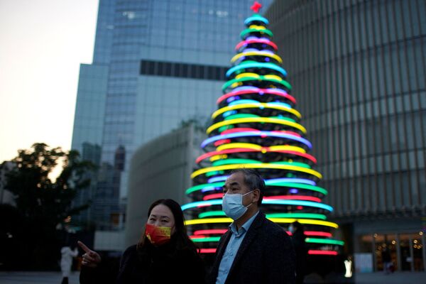 Люди стоят возле зажженной рождественской елки у торгового центра в Шанхае, Китай. - Sputnik Армения