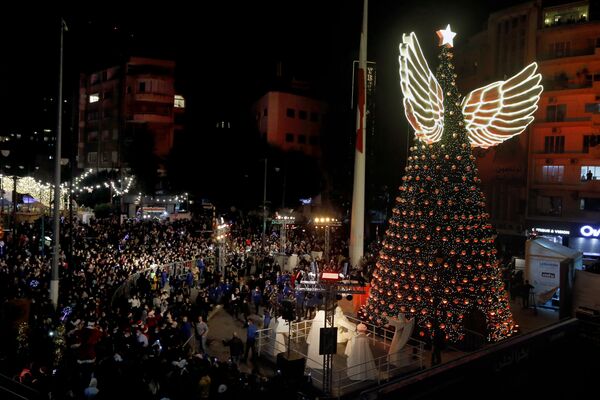 Люди собираются во время освещения гигантской рождественской елки во время празднования Рождества на площади Сассин в районе Ахрафие в Бейруте, Ливан. - Sputnik Армения