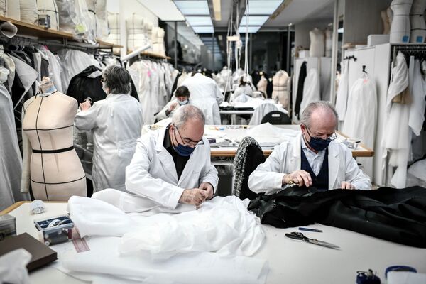 Сотрудники работают над одеждой от кутюр в мастерской дома моды Christian Dior в Париже 20 января 2021 года. Из-за Covid модные презентации стали виртуальными: неделя виртуальных показов мод начинается 25 января. - Sputnik Армения