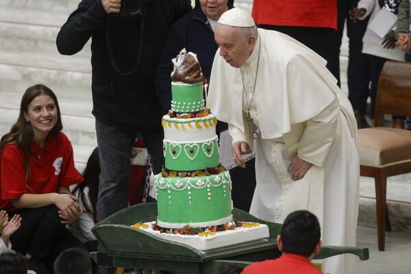 Папа Франциск задувает свечу на праздничном торте, который ему принесли дети из  диспансера Святой Марты - Sputnik Армения