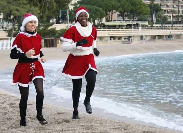 Девушки в костюмах Санта-Клауса совершают пробежку перед зимним купанием в Средиземном море. - Sputnik Армения