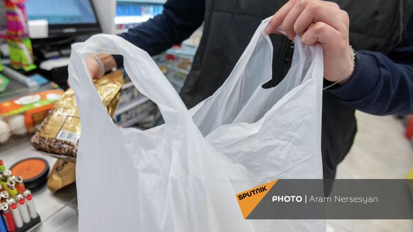 Кассир магазина укладывает покупки в полиэтиленовый пакет - Sputnik Արմենիա