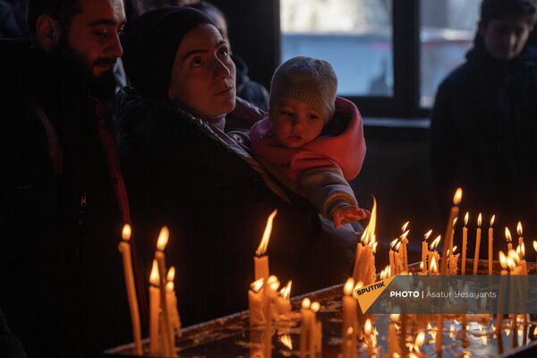 Ընտանիքը Զորավոր սուրբ Աստվածածին եկեղեցում մոմ վառելիս - Sputnik Արմենիա