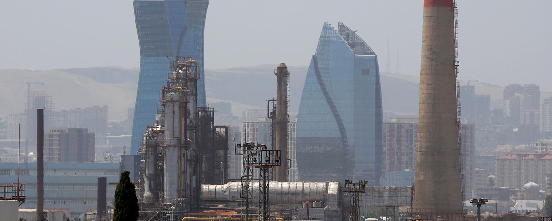 Бакинский нефтеперерабатывающий завод имени Гейдара Алиева виден на фоне небоскреба Socar Tower в Баку - Sputnik Армения, 1920, 30.07.2025